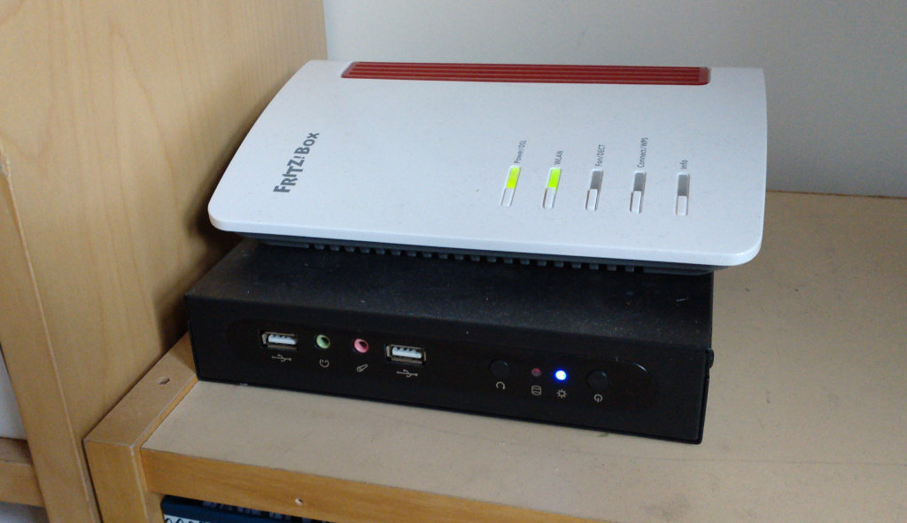 A small computer underneath a Wifi router
